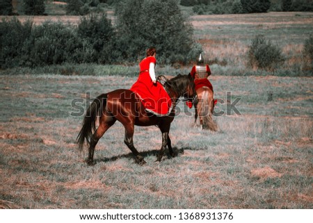 Reconstruction. Medieval horsewoman and horseman are riding their horses in the steppe