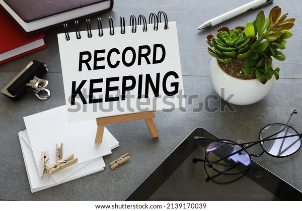 record keeping. text on a notebook on a stand\
near glasses and a tablet and a plant in a pot. business concept.\
education concept.