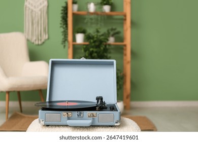 Record player with disk on coffee table in room