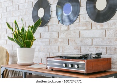 Record player with vinyl disc on table in room
