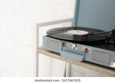 Record player with vinyl disk on wooden shelf