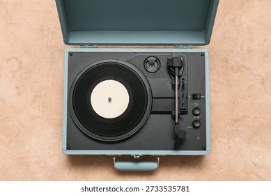 Record player with vinyl disk on beige background