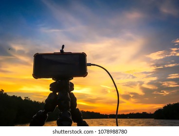 Recording dramatic sunset using smartphone.