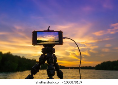 Recording dramatic sunset using smartphone.