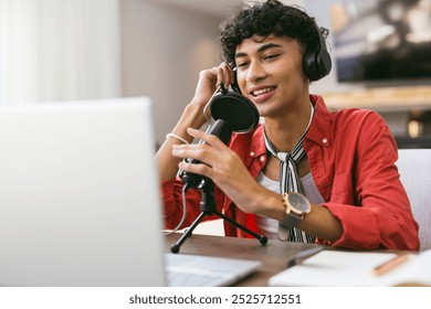 Recording podcast, teenage boy using microphone and laptop at home. Podcasting, broadcasting, home studio, technology, transcription, digital media - Powered by Shutterstock