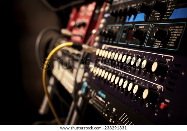 recording studio gears in rack, focus on knob\
& shallow dept of\
field