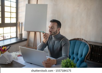 Recording Voicemail. Bearded Businessman Recording Voicemail For Wife While Working On Laptop