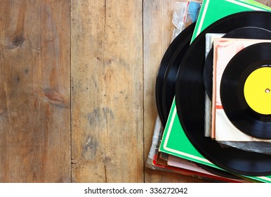 records stack with record on top over wooden table. vintage filtered
