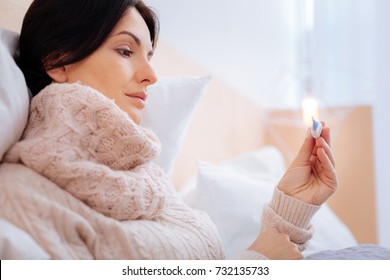 Recovering woman looking pleased while discovering her temperature - Shutterstock ID 732135733