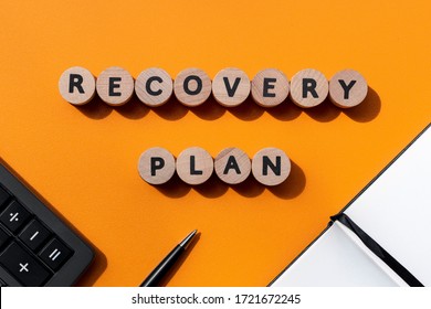 Recovery Plan Inscription, Calculator, Pen And Notebook On Office Desk. Business Concept. Recovering Business Sectors Affected By The Global Financial Crisis Due To The Coronavirus Pandemic.Top View