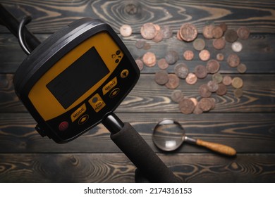 Recreational Metal Detector And Ancient Coins On The Wooden Table Background Top View.