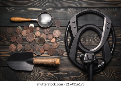 Recreational Metal Detector And Ancient Coins On The Wooden Table Background. Treasure Hunting Concept Background.