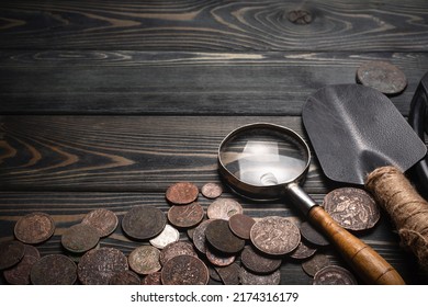 Recreational Metal Detector And Ancient Coins On The Wooden Table Background With Copy Space. Treasure Hunting Concept Background.