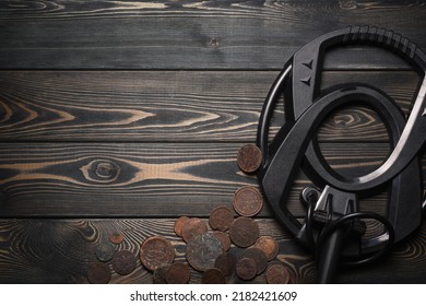 Recreational Metal Detector And Ancient Coins On The Wooden Table Background With Copy Space. Treasure Hunting Concept Background.