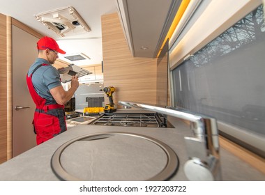 Recreational Vehicle RV Camper Appliances Caucasian Technician In His 40s Repair Air Condition Unit Inside Modern Travel Trailer. 