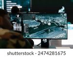 Recruit analyzes satellite radar CCTV footage in control room, monitoring the infantry unit during a battle. Army soldier working in the reconnaissance and defense division command post.