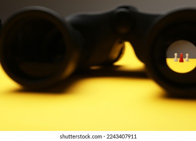 Recruiter searching employee. Red and white pawns visible through binoculars on yellow background - Powered by Shutterstock