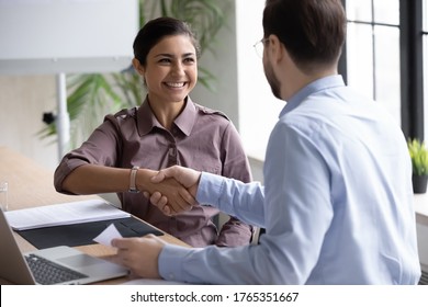 Recruiter shaking successful smiling Indian businesswoman candidate hand at meeting, congratulating with getting new job, manager making great deal with customer, diverse business partners greeting - Powered by Shutterstock