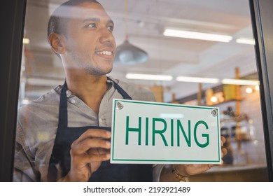 Recruitment, Advertising And Small Business Owner With Hiring Sign Board On Window Or Door Of Cafe Or Restaurant, Happy And Positive. Young Business Man Excited Open After End Of Covid Virus