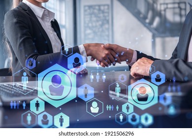 Recruitment concept of hiring of a new talented specialists for international company. Handshake as a concept of agreement to sign an employment contract. Social media hologram icons.