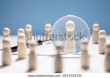 Recruitment and job search magnifying glass with wooden people concept for human resources and choosing the right people