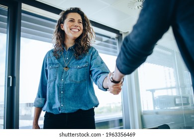 Recruitment manager shakes her hand with male candidate as he gets the job. Businesswoman handshake with a man in office meeting room. - Shutterstock ID 1963356469
