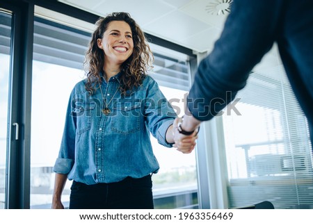 Recruitment manager shakes her hand with male candidate as he gets the job. Businesswoman handshake with a man in office meeting room.