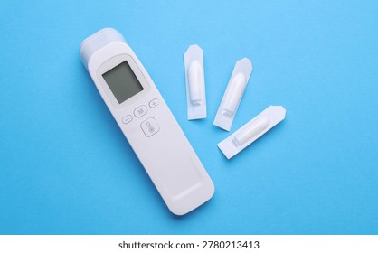 Rectal suppositories and thermometer on a blue background
