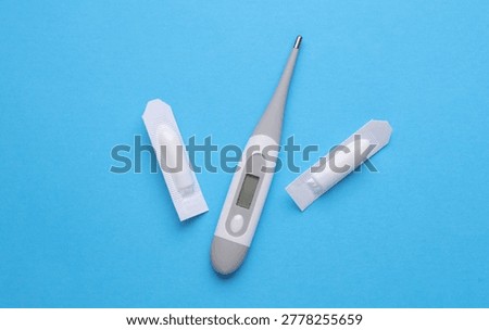 Rectal suppositories and thermometer on a blue background