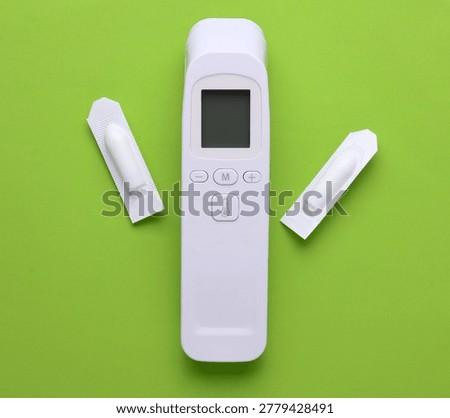 Rectal suppositories and thermometer on a green background