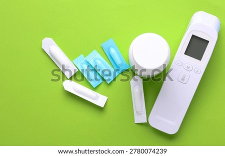 Rectal suppositories and thermometer on a green background