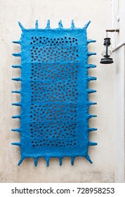 Rectangular blue sculpture hung on the wall