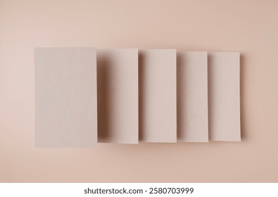 rectangular empty kraft cardboards, at different levels, form steps on a beige background, top view