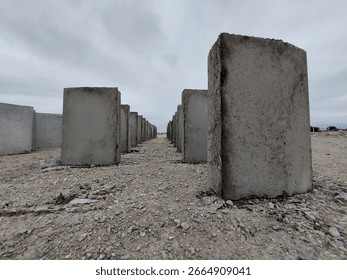 Rectangular gray cement blocks laid parallel to the ground to dry.