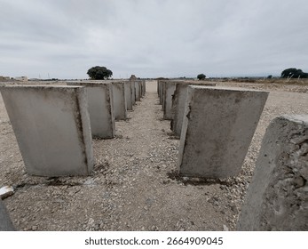 Rectangular gray cement blocks laid parallel to the ground to dry.