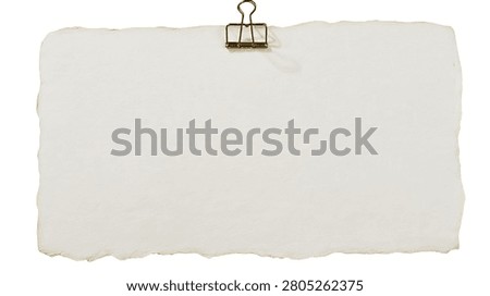 Rectangular handmade paper sheet with rough deckled edges held by metal clip