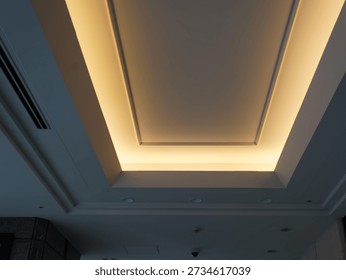 rectangular Illuminated Ceiling Light Fixture with a Soft Glow, Set Against a Dark Ceiling with Parallel Slats or Grooves.