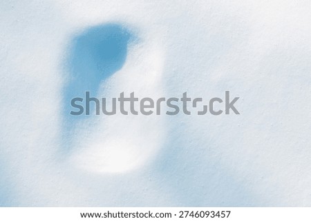 Rectangular imprint, covered with snow, on the fluffy, snowy surface with sunlight.