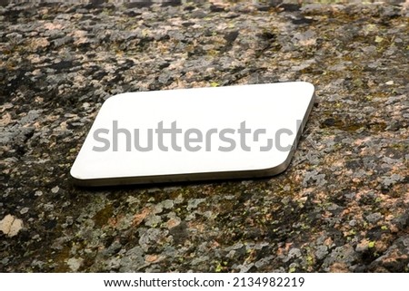 Rectangular metal plate on the surface of an old stone. Mockup background