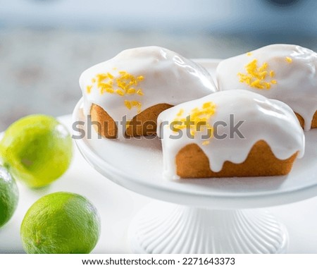 Rectangular muffins covered with white cream icing and sprinkled with lime zest