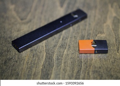 Rectangular Nicotine Vape Pen With Cartridge On A Wood Coffee Table.