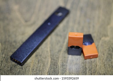 Rectangular Nicotine Vape Pen With Cartridge On A Wood Coffee Table.