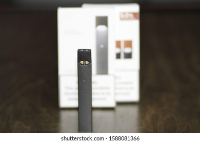 Rectangular Nicotine Vape Pen On A Wood Coffee Table.