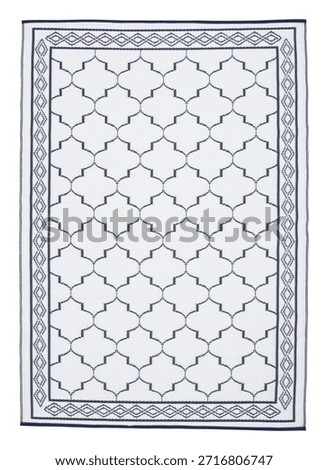 A rectangular outdoor rug with a white background and a repeating navy blue trellis or quatrefoil pattern. A decorative geometric border frames the entire rug. The woven texture is evident.