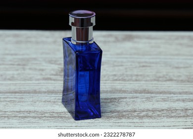 A rectangular perfume bottle made of blue glass on the table.
