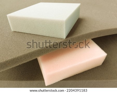 rectangular pieces of cream, gray and brown foam sponge neatly stacked. soft colored material with different thickness