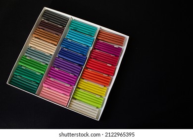 rectangular pieces of multicolored plasticine, in a white box on a black background
