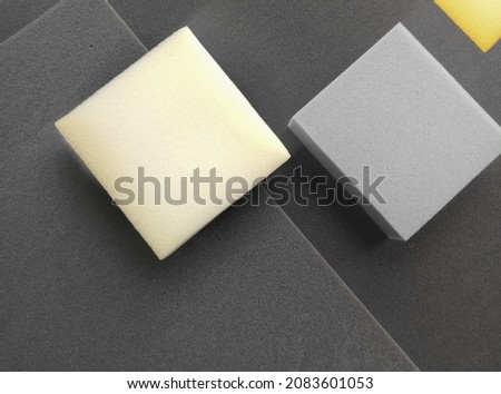 rectangular pieces of sponge foam material with variations in black, gray, yellow and cream colors.
