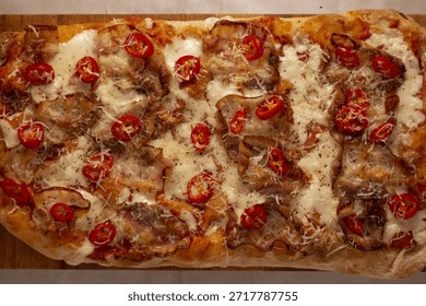 Rectangular pizza layered with meatballs cherry tomatoes and mozzarella, hearty proteinrich topping and rustic oven finish ideal