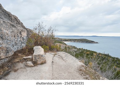 A rectangular rock is placed for hikers to take a break and view the Atlantic ocean. This rest area is on the Gorham Mountain in Acadia National Park                    